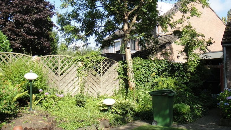 Moderne achtertuin met gazon en waterpartij vanaf de woning gezien